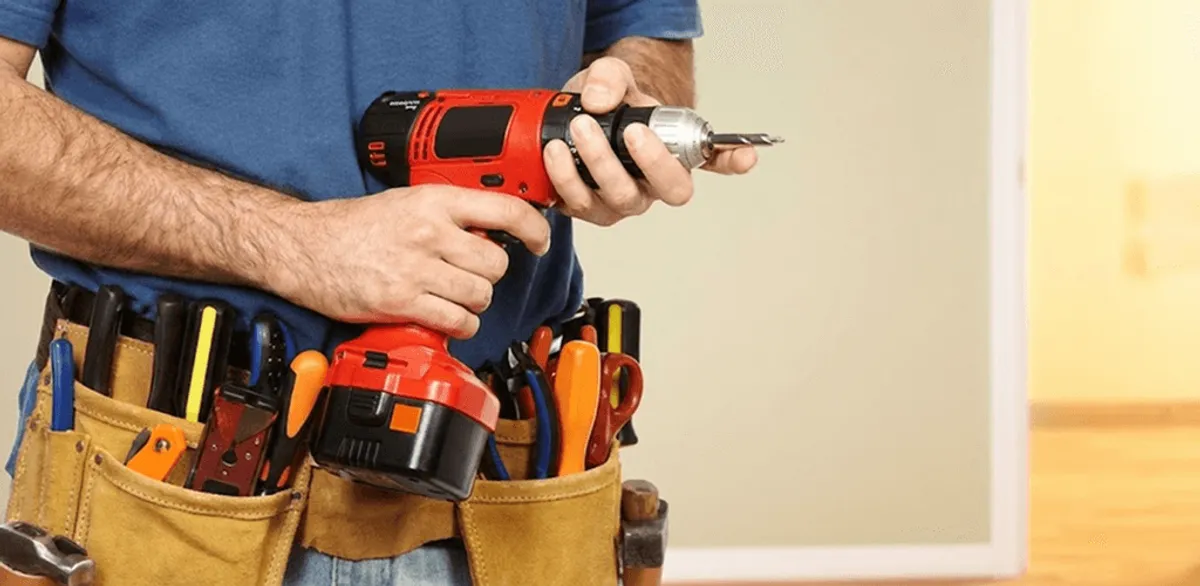 Handyman holding a power drill for home repairs and installations in Lowell, MA